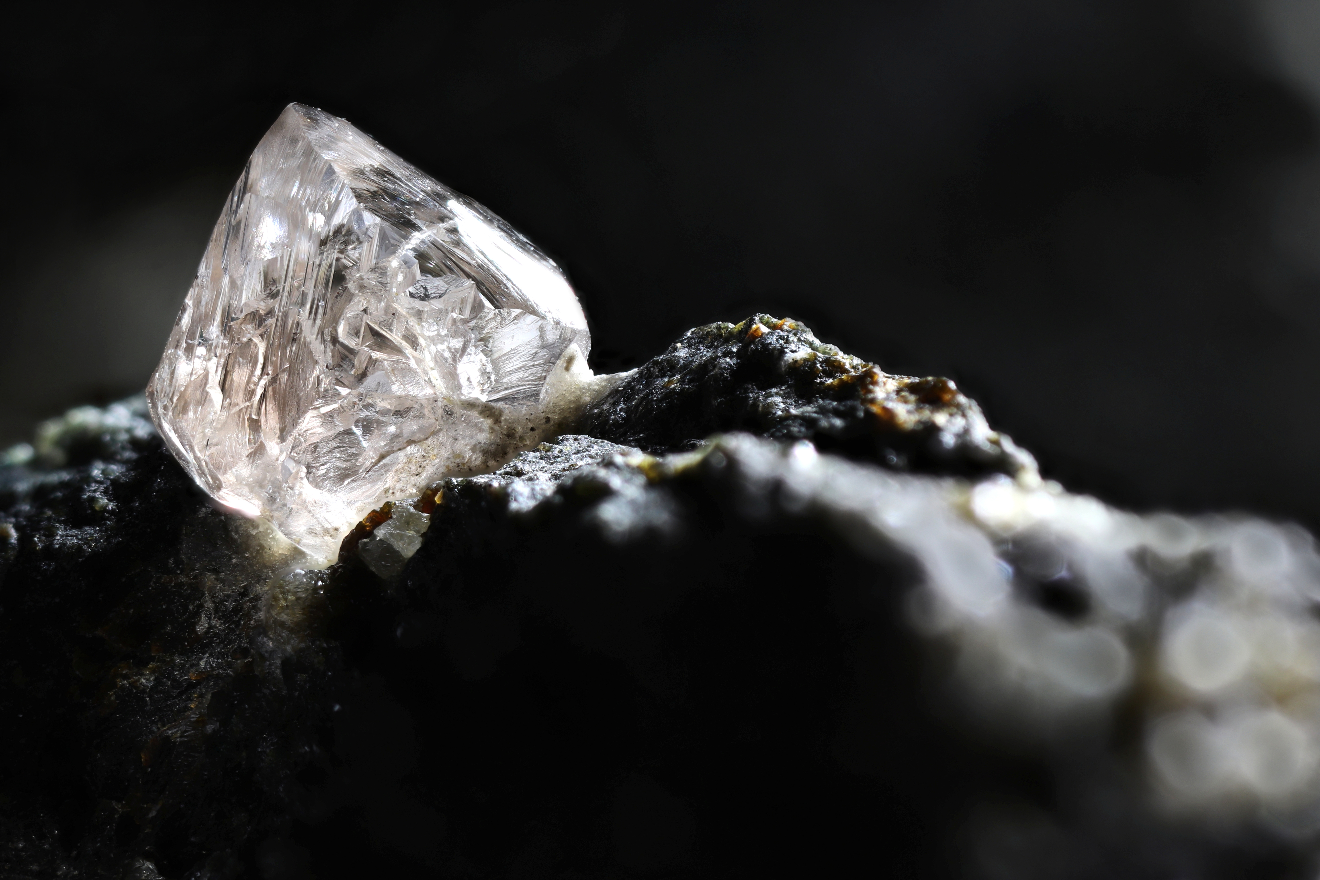 A diamond sitting in a dark area.; What Can Diamonds Tell Us About Earth?