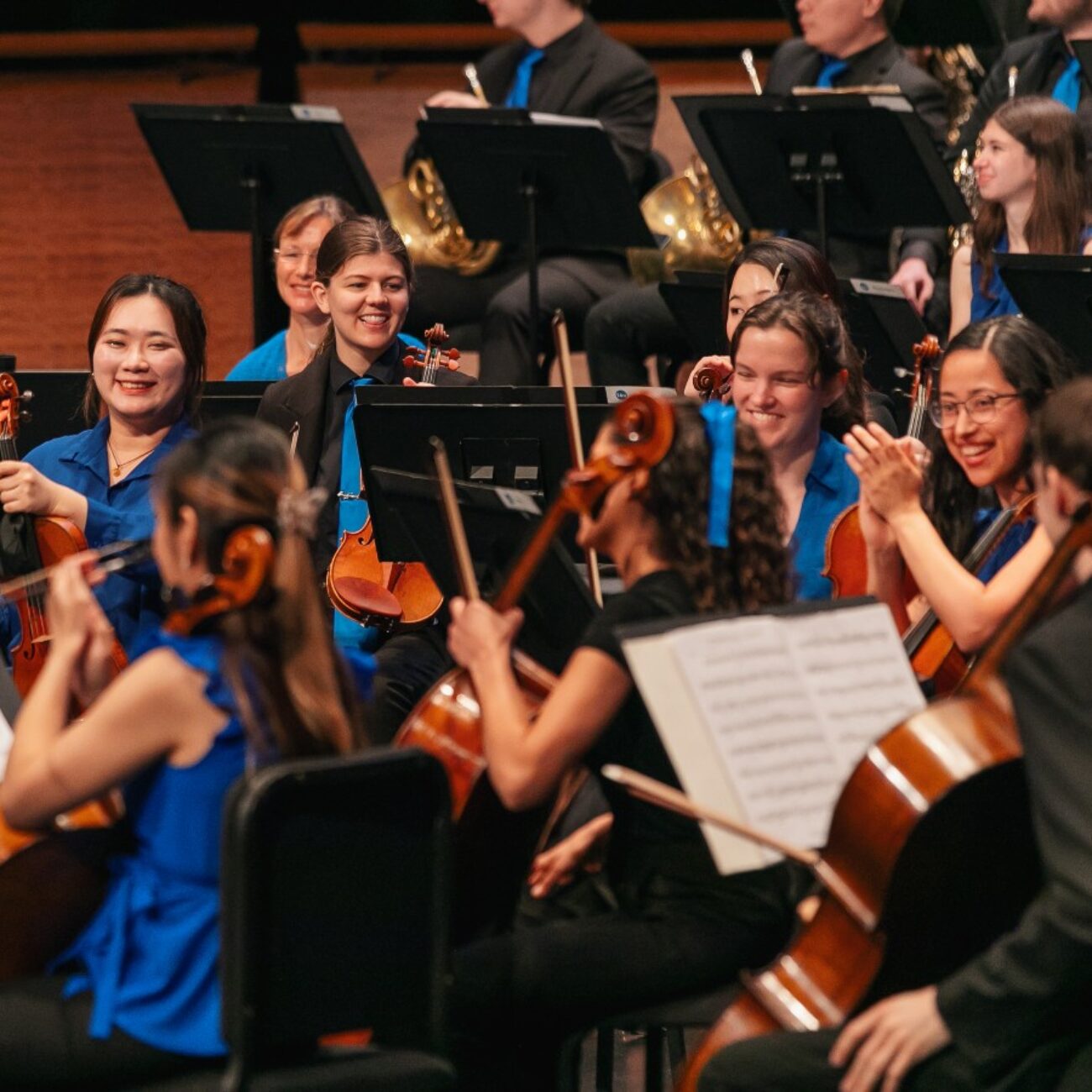 A group of musicians smiles and holds up their instruments.; The Nutcracker &amp; The Planets