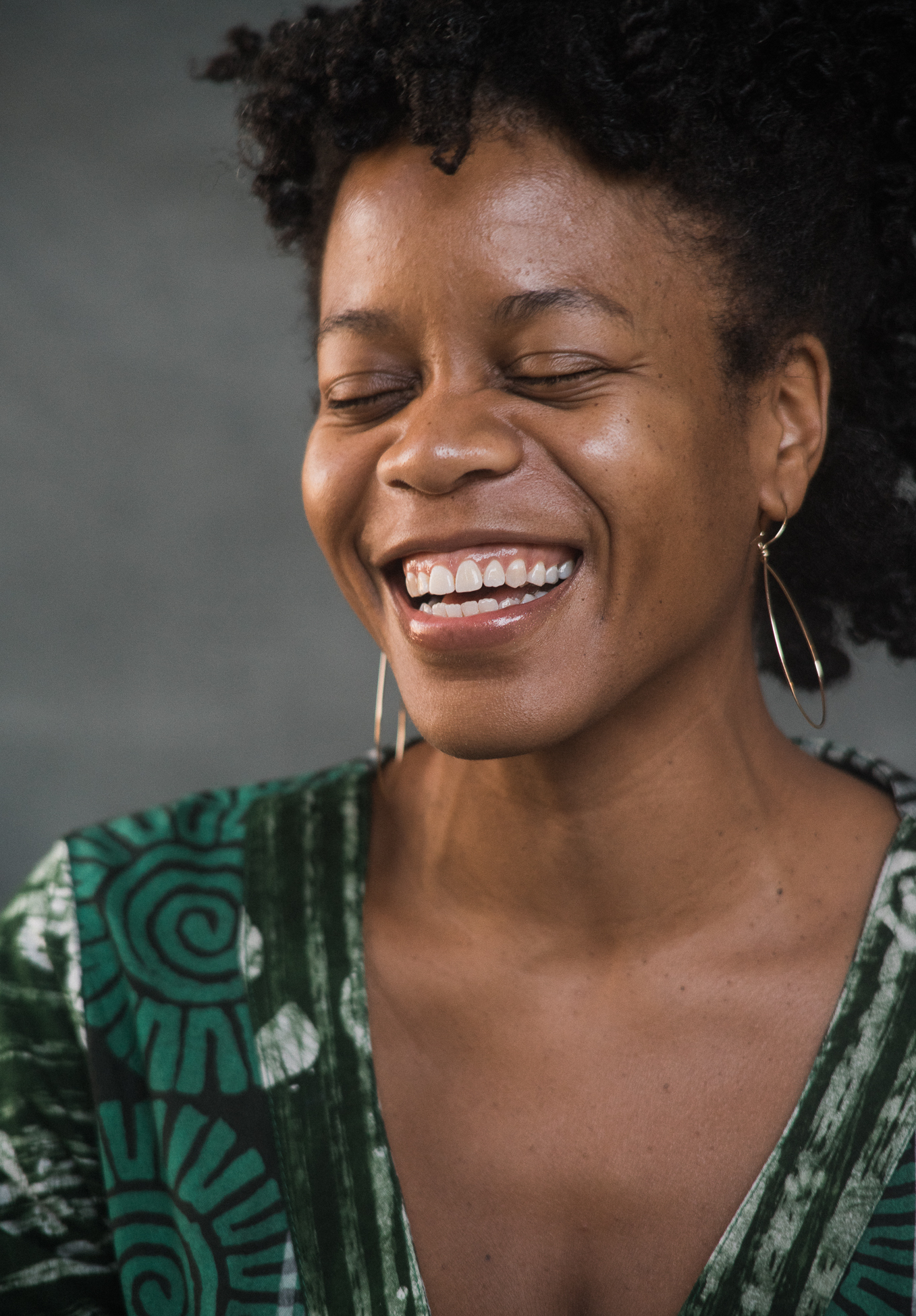 An author photo of a woman with earrings and a green dress laughing.; Doorways&nbsp;Into&nbsp;Ekphrasis