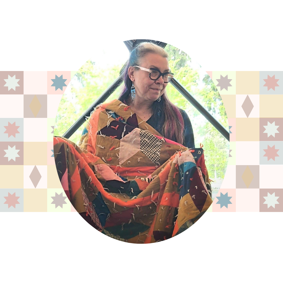 An image of a woman sitting up covered by a patchwork quilt.; &quot;The Song Blanket&quot; led by Rebecca Hass