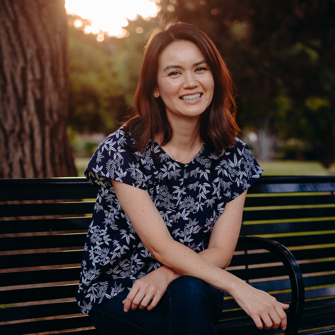 A photo of the author sitting on a bench in a blue blouse.; The Mass Renunciations of US Citizenship at Tule Lake