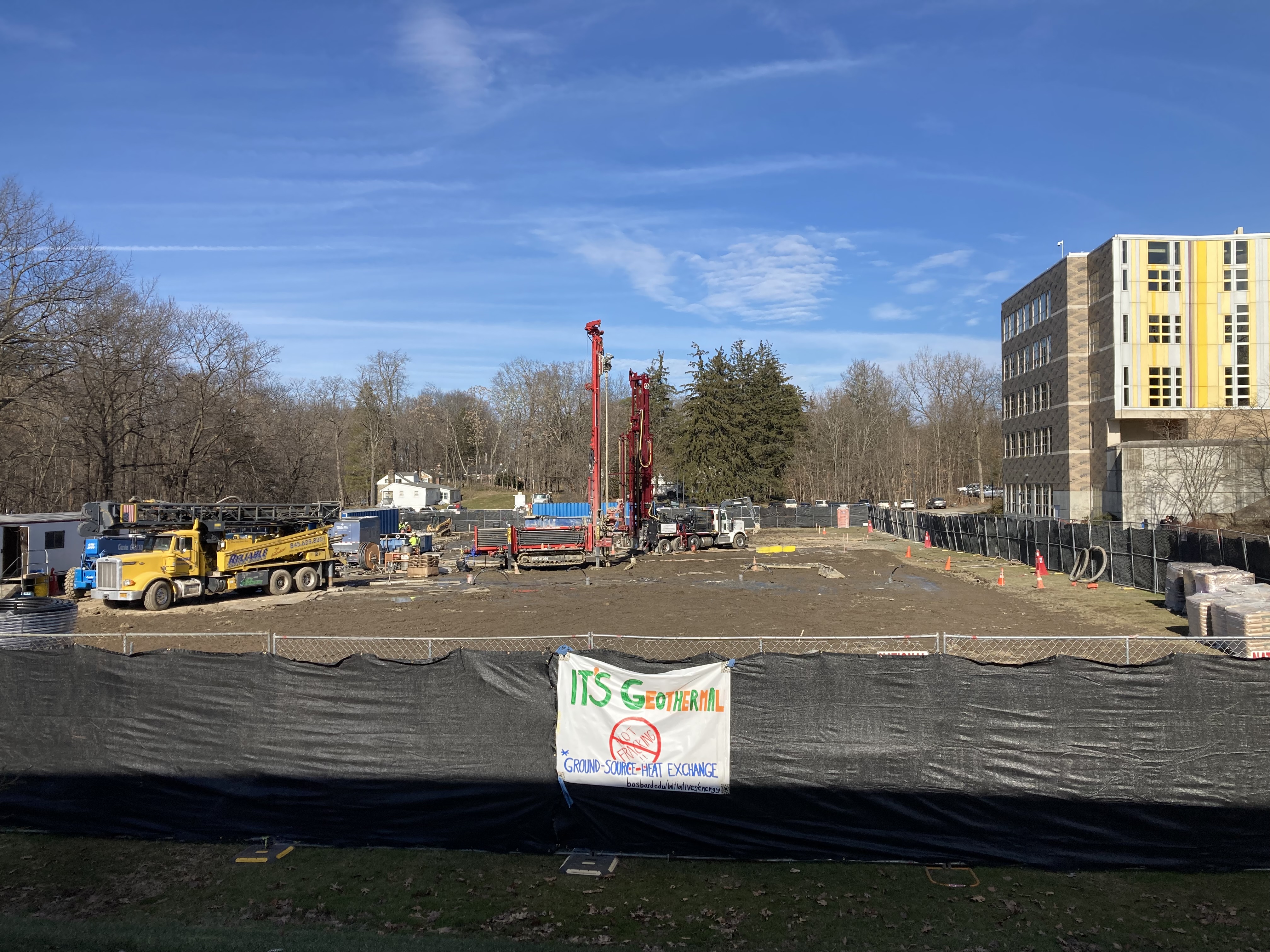 An image of a lot filled with construction trucks.; Visit https://bos.bard.edu/