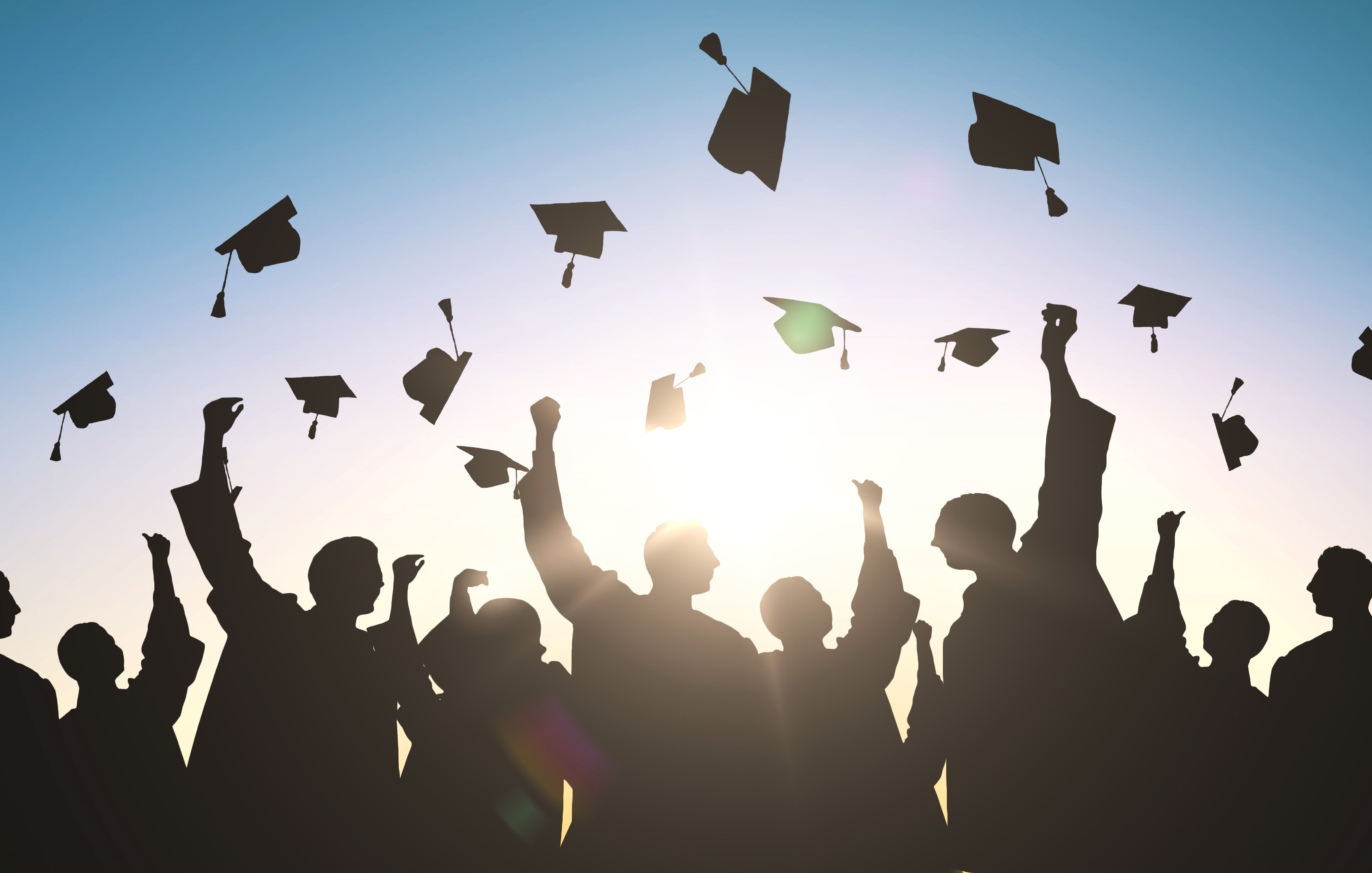 A group of graduating students throwing their caps into the air.; Senior Project Poster Session