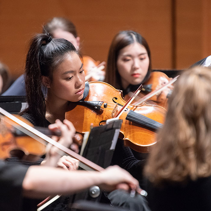 Dual Degrees ColumnTwo students playing violins in concert.